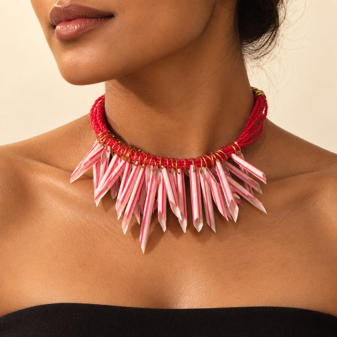 Cape Monze — a red net-rope collar with washed-up straws cut to points