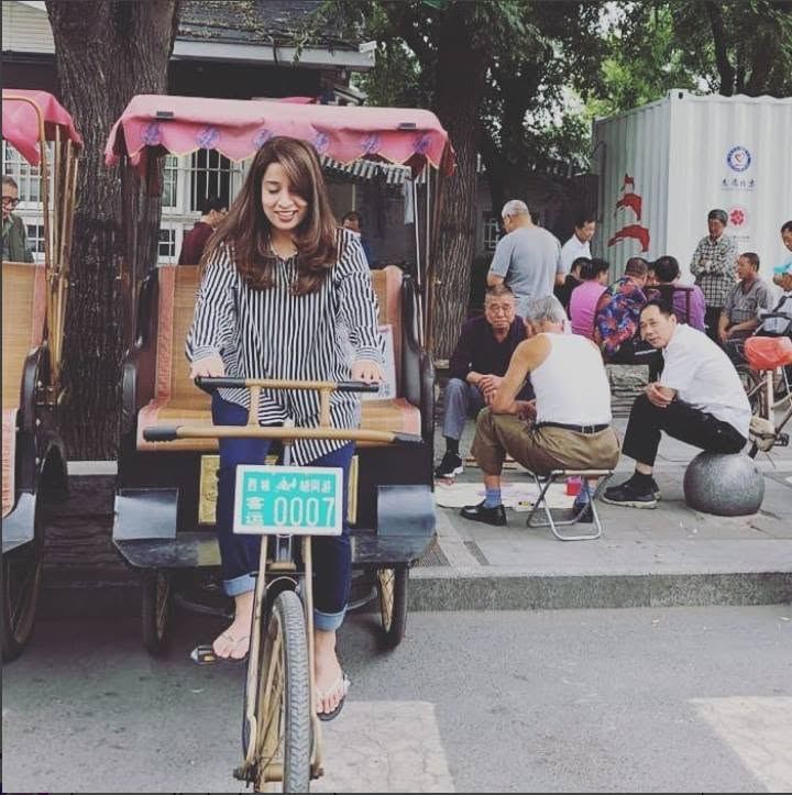 beijing. a pedicab, parked, and the park doing its afternoon.