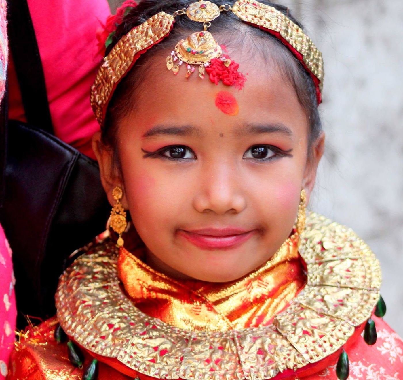a child in her mother’s gold, holding still for one frame.
