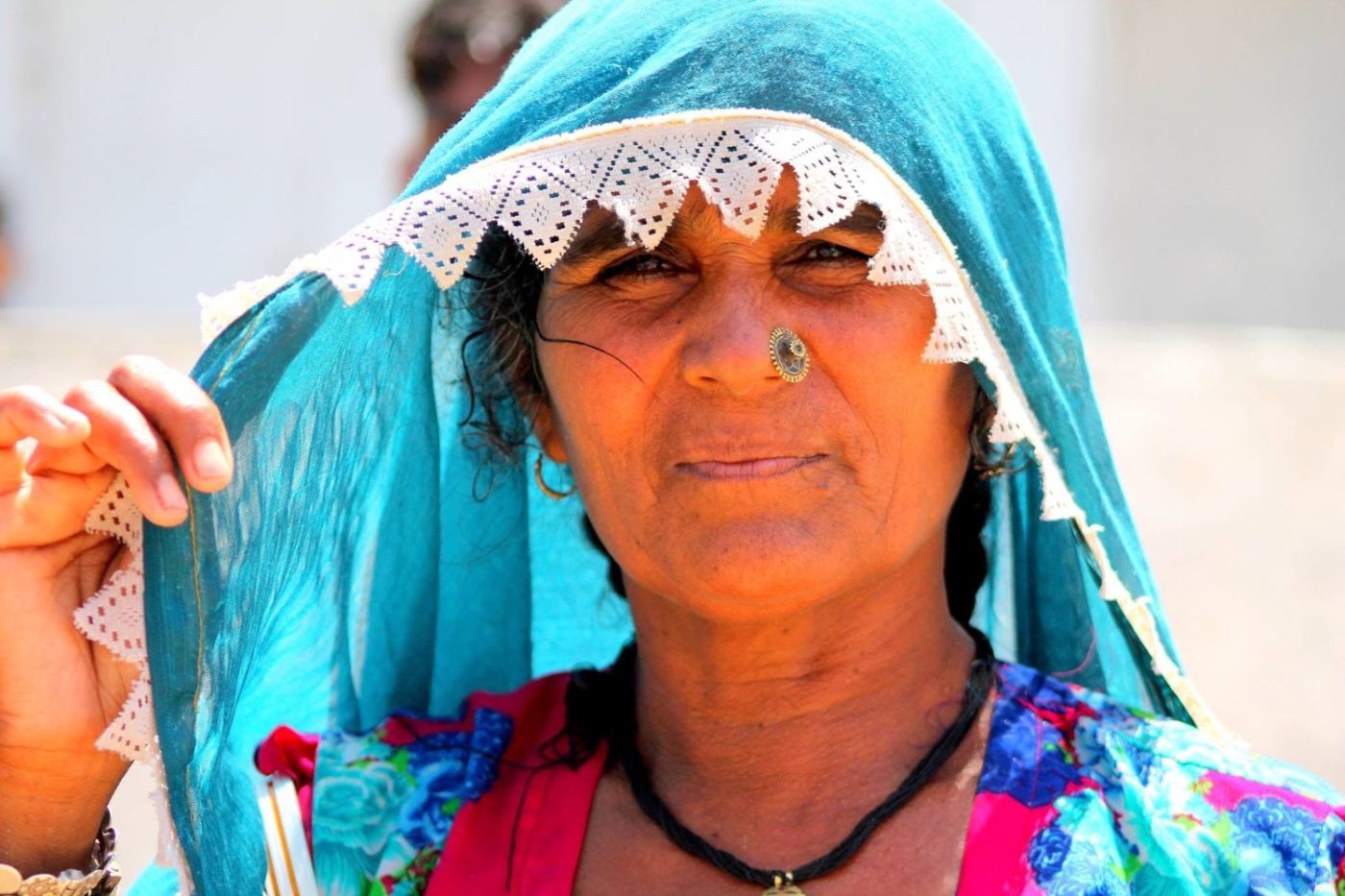 she lifts the lace to show the nose ring. it is older than the border.