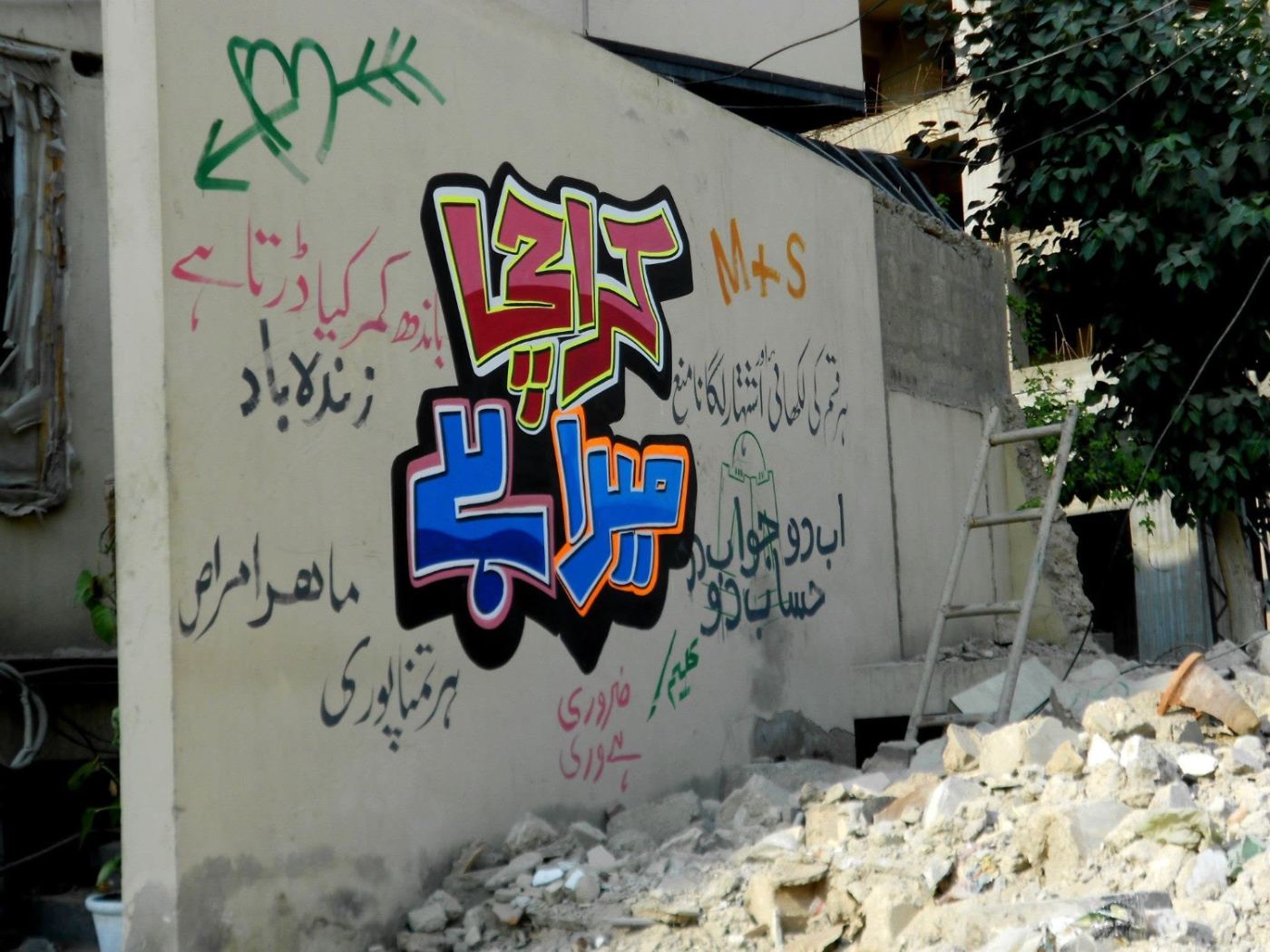 a karachi wall, arguing back in urdu.