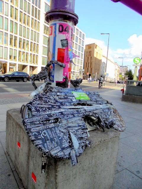 a moped that stopped being a moped. every hand that passed left a layer until the object underneath went theoretical. the stickers are berlin&rsquo;s census &mdash; everyone who came through, needing to leave proof.