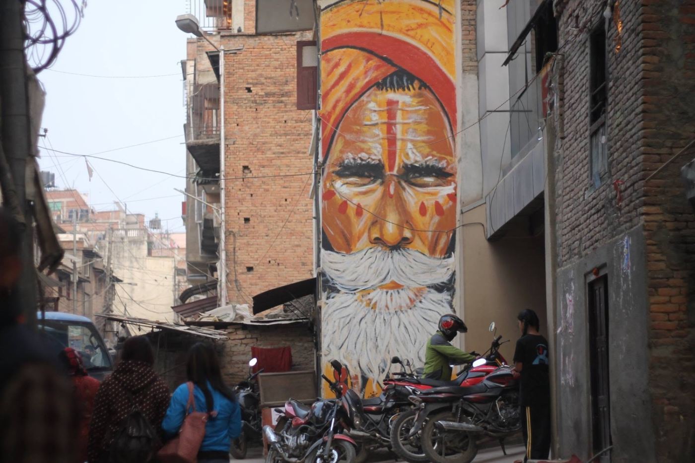 a face painted three storeys high over a narrow street.