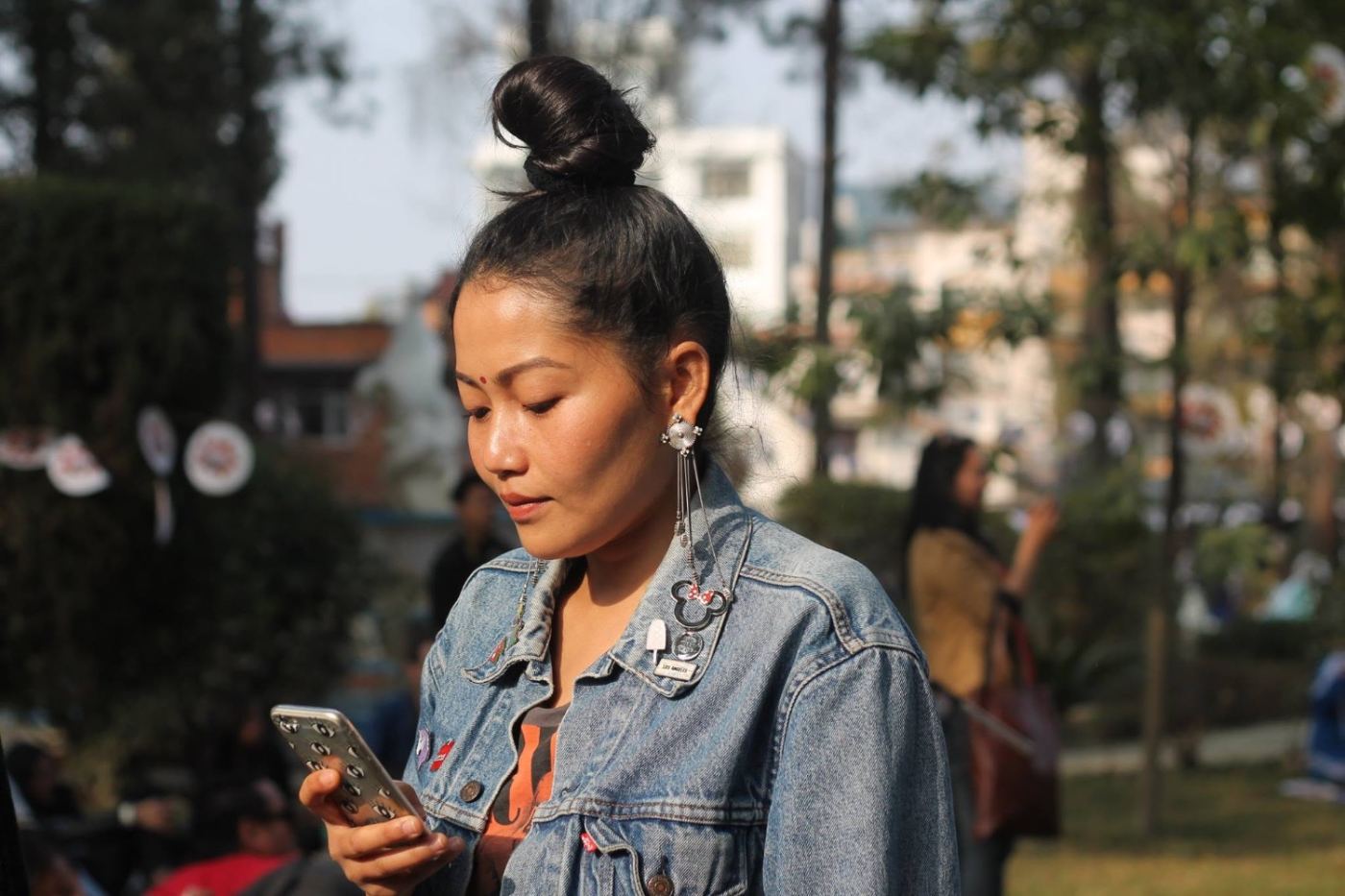 kathmandu on a saturday: denim, topknot, phone.