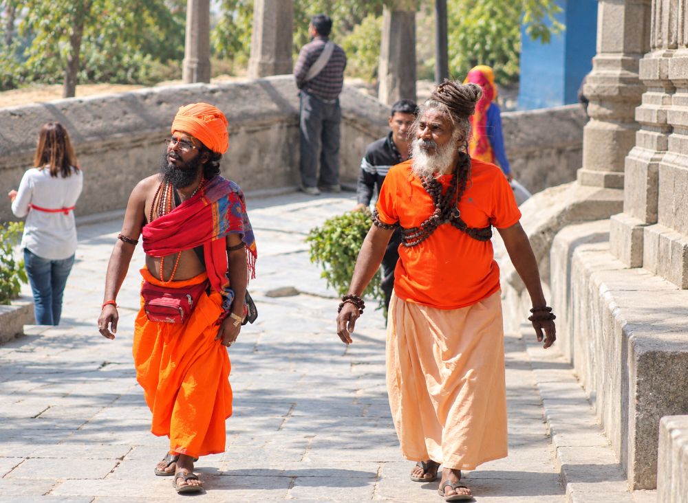 Two sadhus in orange walking through the temple complex