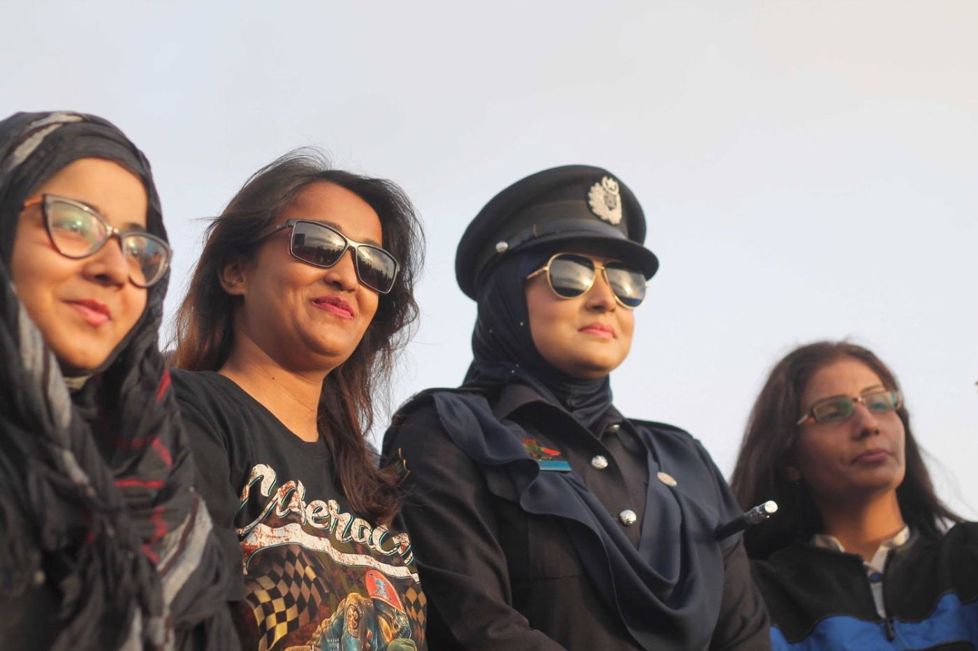 four women in sunglasses. one of them is the officer.