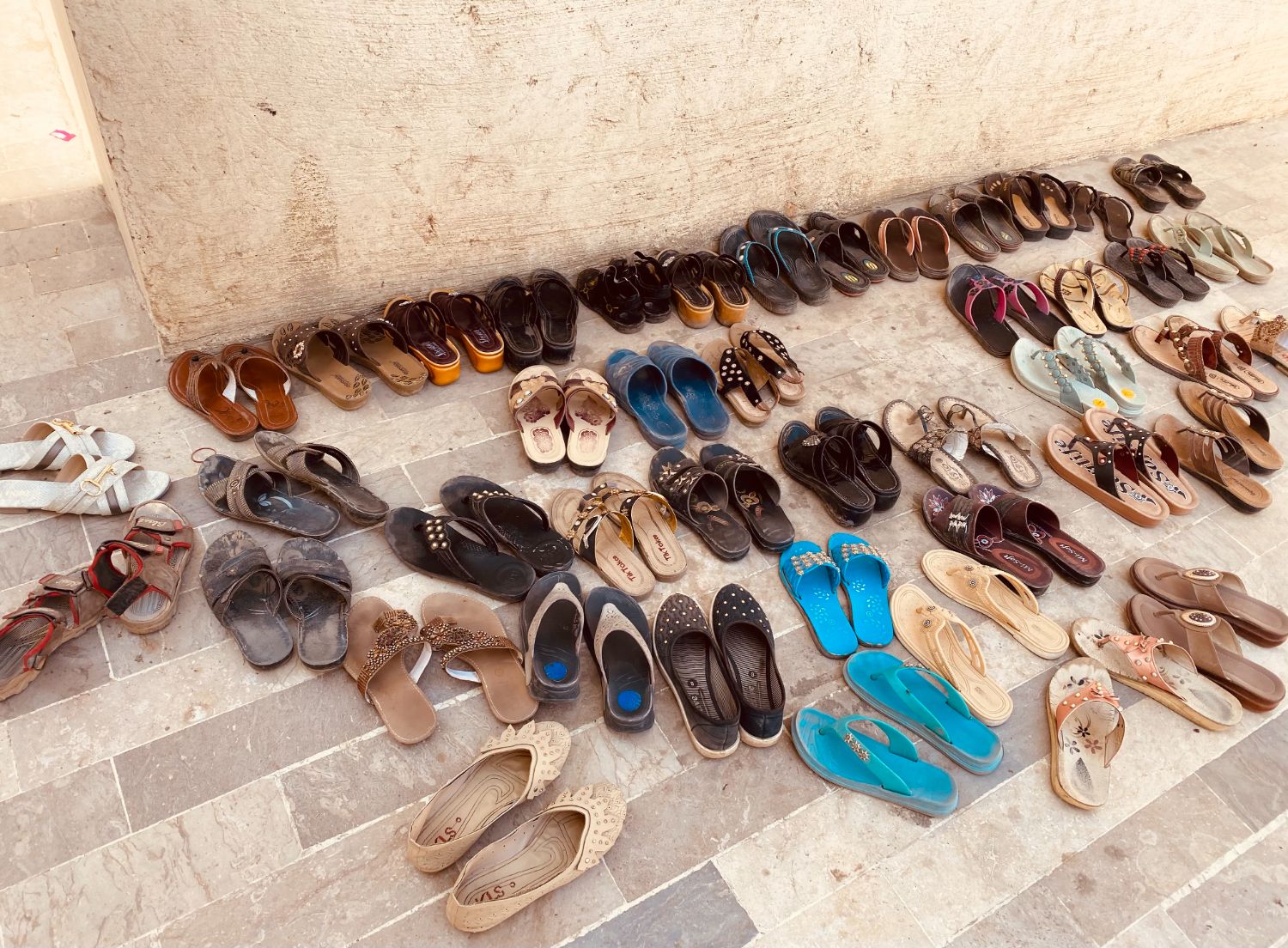 Rows of sandals left outside a training room