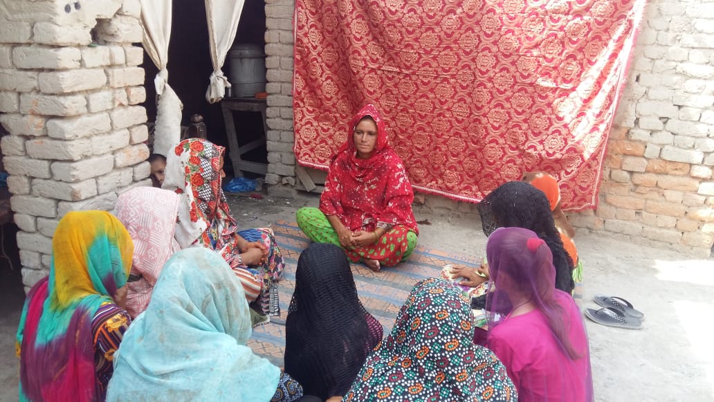 A champion in yellow standing, addressing a courtyard full of women