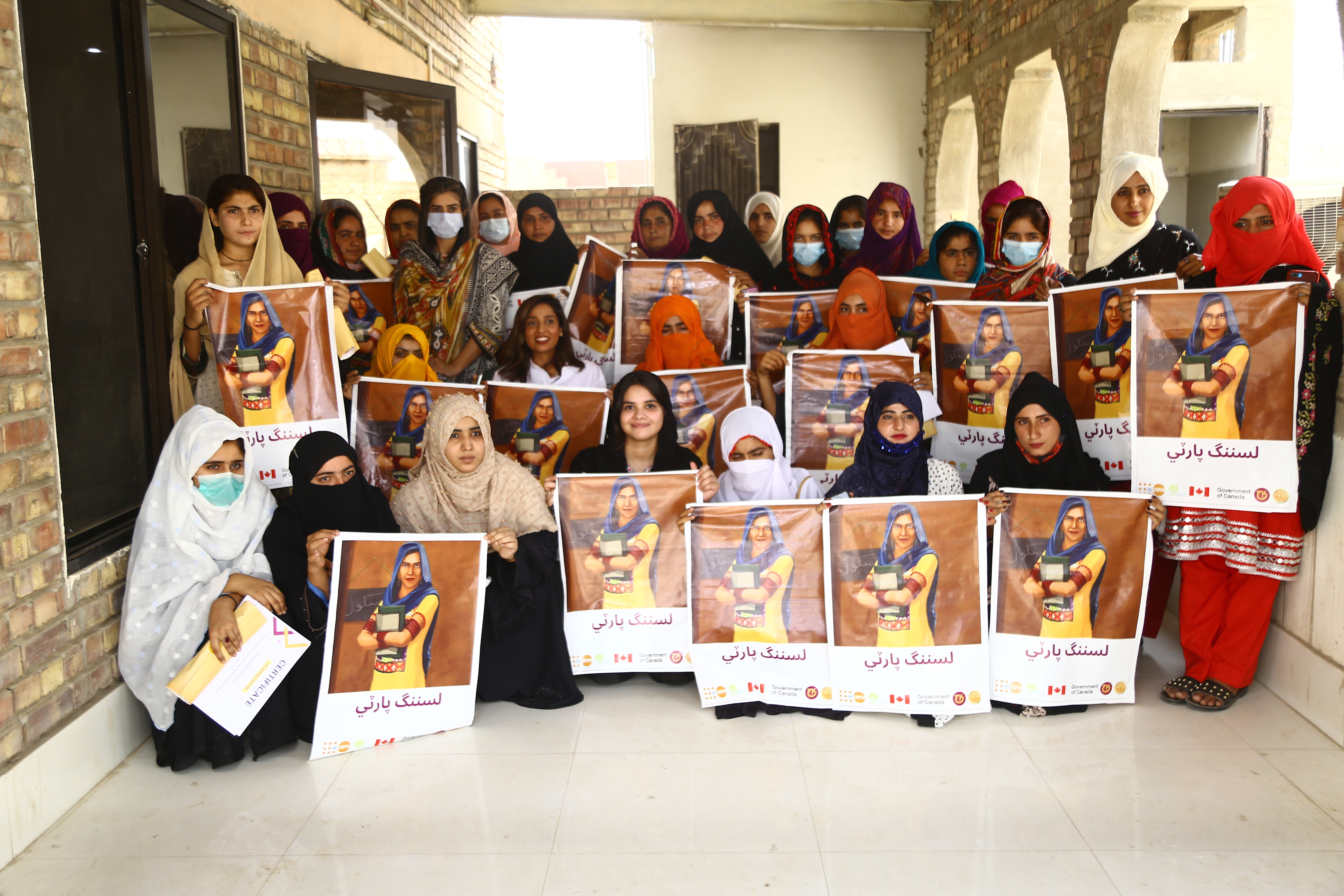 Thirty women and girls holding Listening Party posters