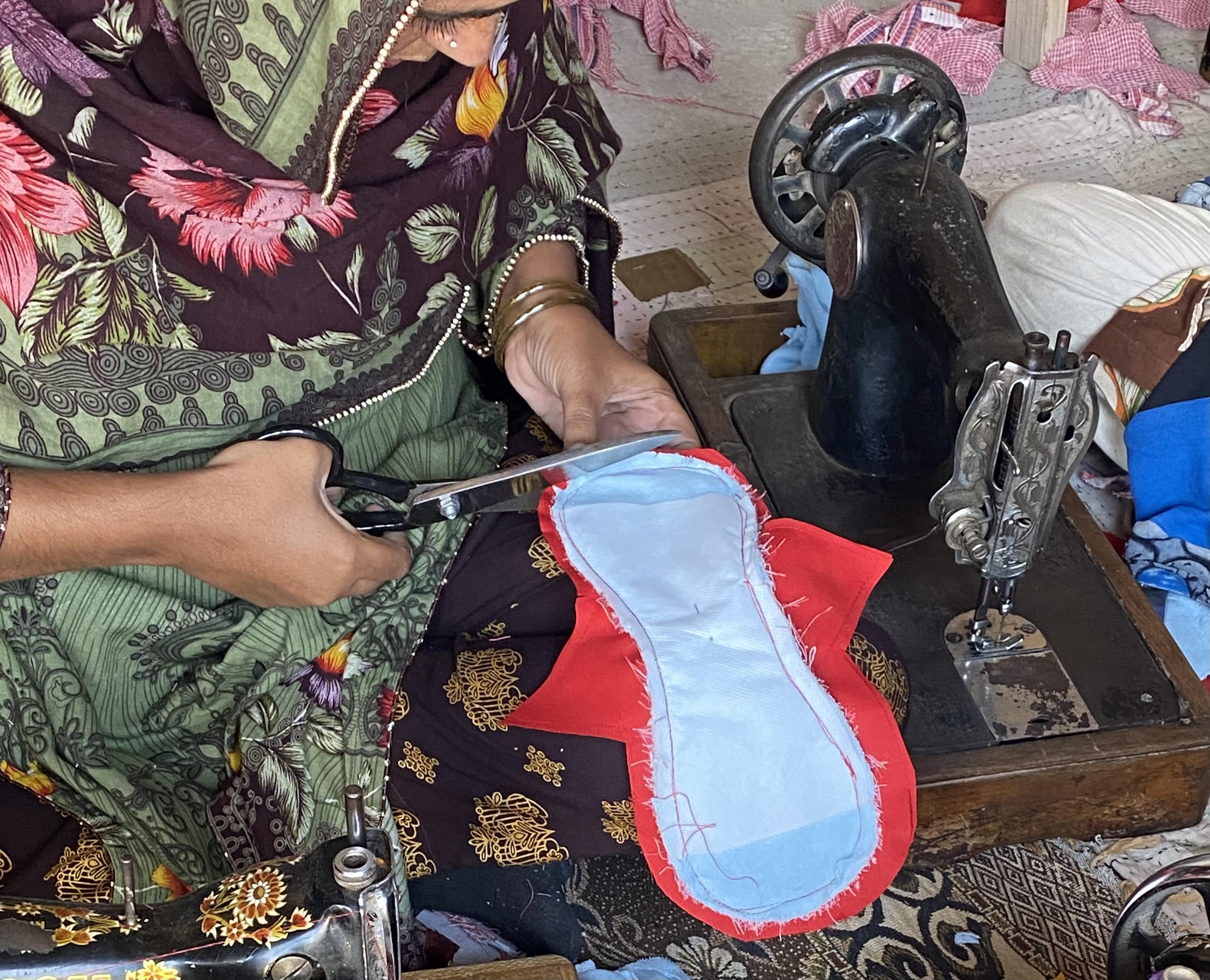 Hands trimming a reusable pad with scissors