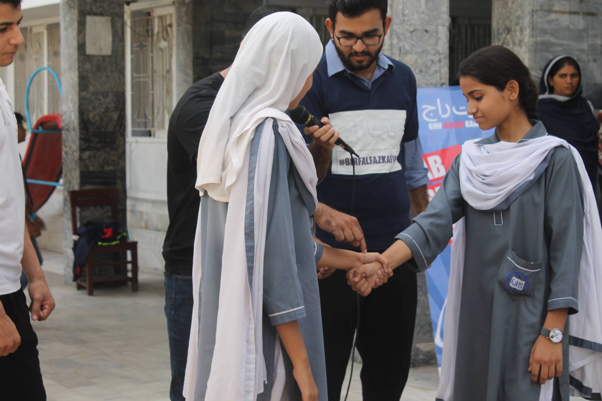 An instructor demonstrates a grip-release technique in a courtyard