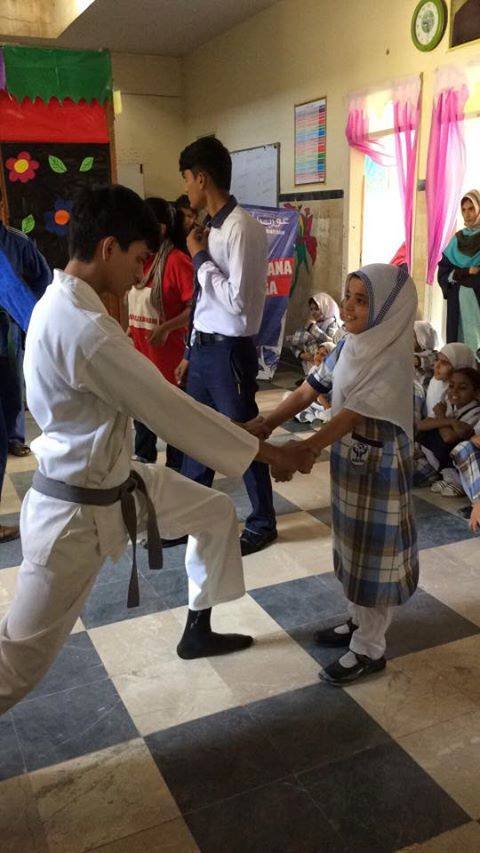 A karate instructor practices a technique with a young student