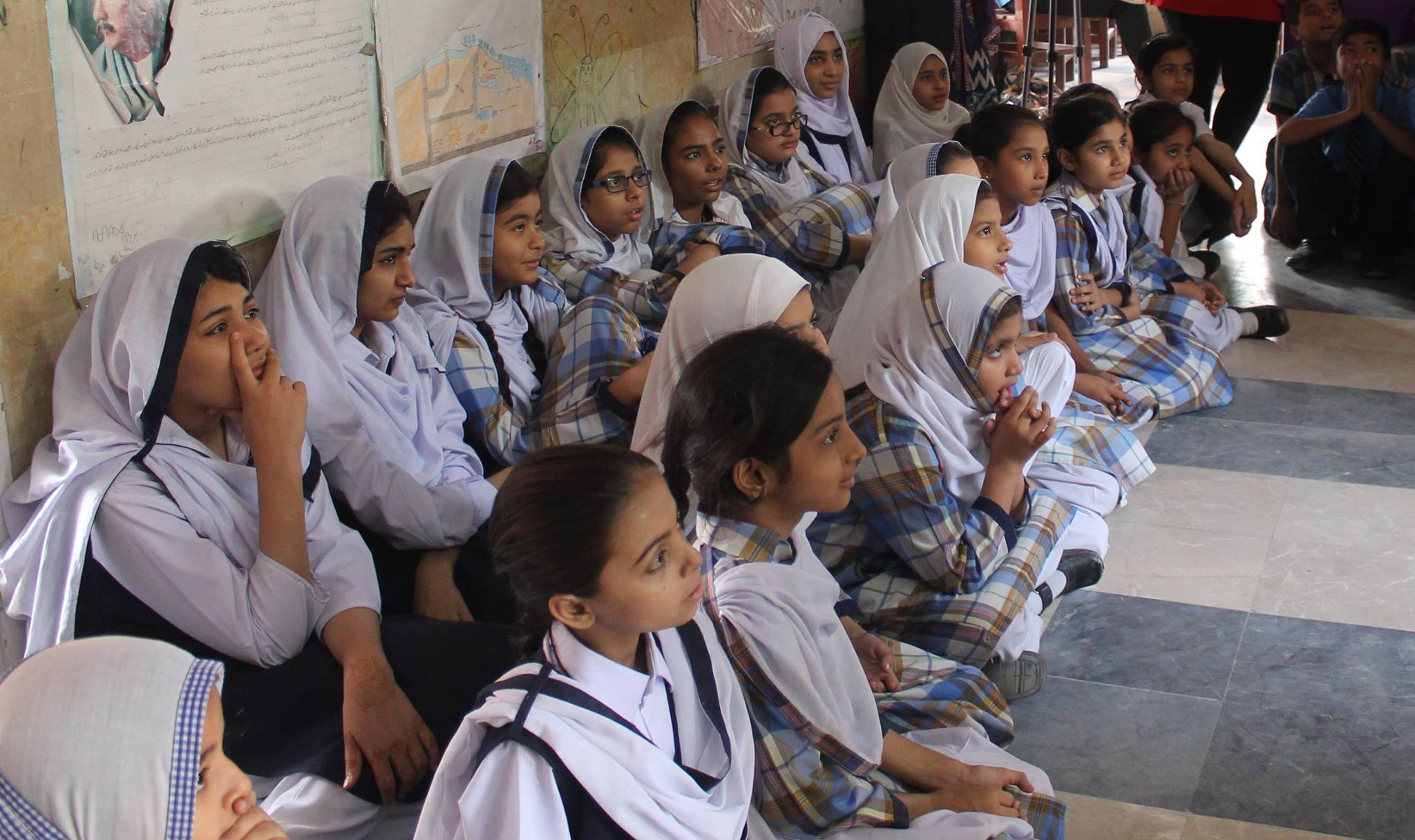 Rows of schoolgirls watching a self-defence demonstration intently